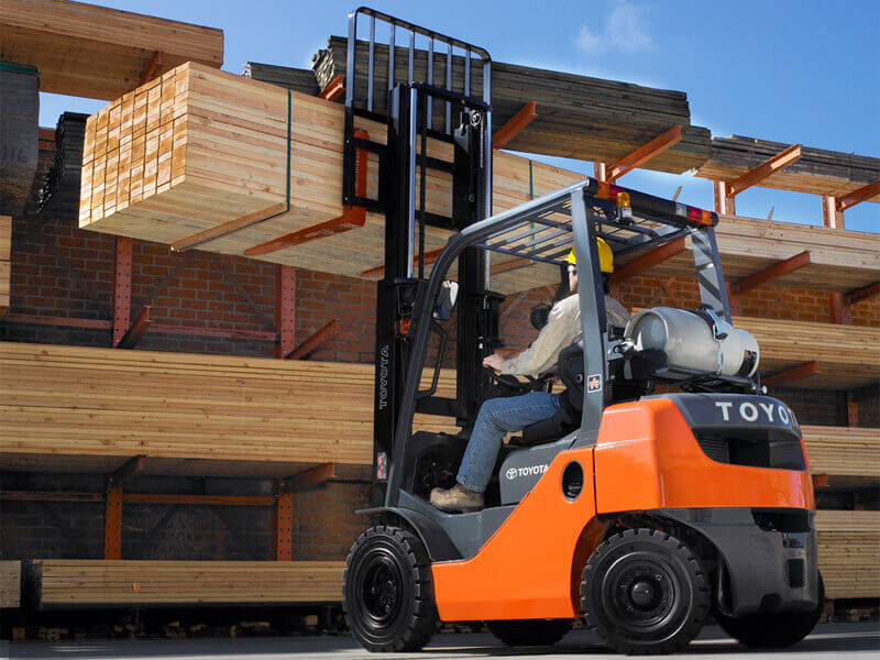 Toyota forklift operator moving a shipment of wooden boards